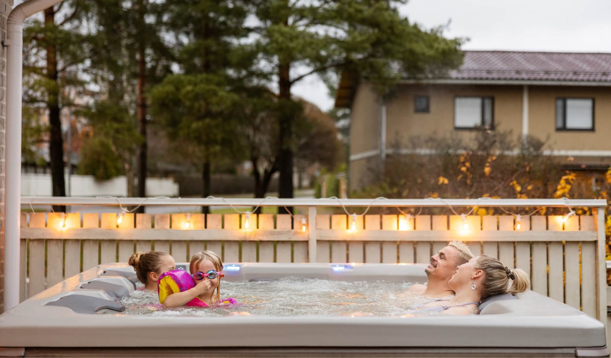 Family relaxing in a Bullfrog hot tub on a fall evening